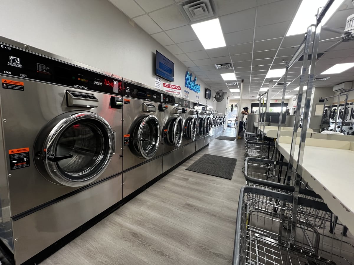 Clean modern laundromat interior with washers and folding tables